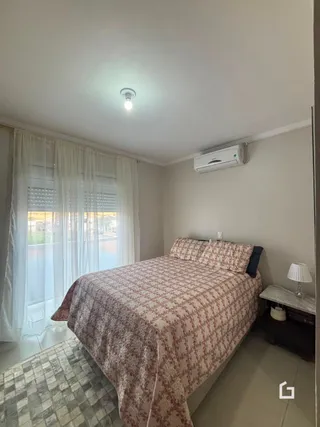 Quarto com cama e janela em ambiente interno.