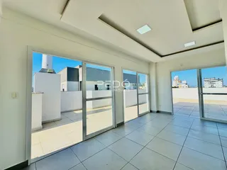 Ambiente interno com portas de vidro que dão acesso a uma área externa de piso cerâmico.