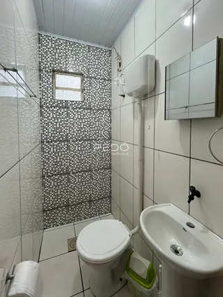 Foto de um banheiro com revestimento de azulejos brancos e pretos.
