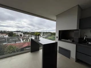 Vista ampla de uma sala de estar moderna com vista para a paisagem urbana.