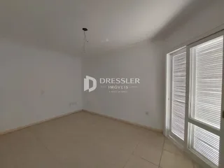 Interior de um cômodo com piso de cerâmica e paredes brancas.