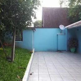 Vista externa mostrando um pátio com parede azul e gramado.