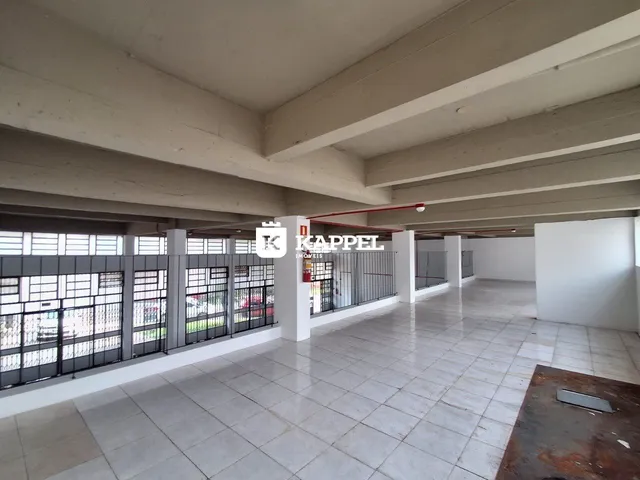 Hall de um imóvel com piso de cerâmica e estrutura de concreto aparente.