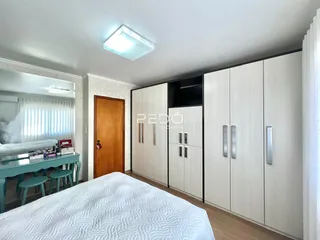Quarto com armários embutidos e piso de madeira.