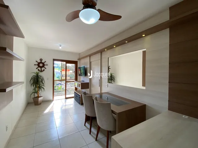 Interior de uma sala de estar moderna com piso de cerâmica e armários em madeira.