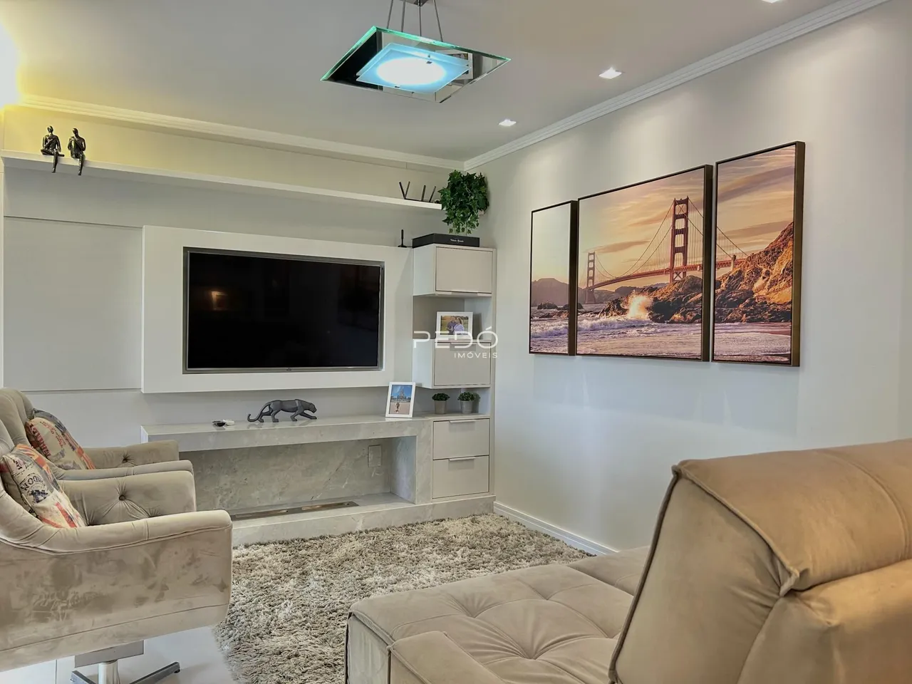 Sala de estar moderna com sofá e decoração de parede.