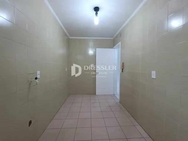 Corredor interno com piso e paredes revestidos de cerâmica.