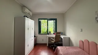 Quarto com armário e cama de cor rosa.