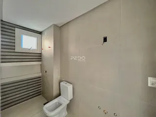 Hall de entrada com revestimento moderno e vaso sanitário branco.