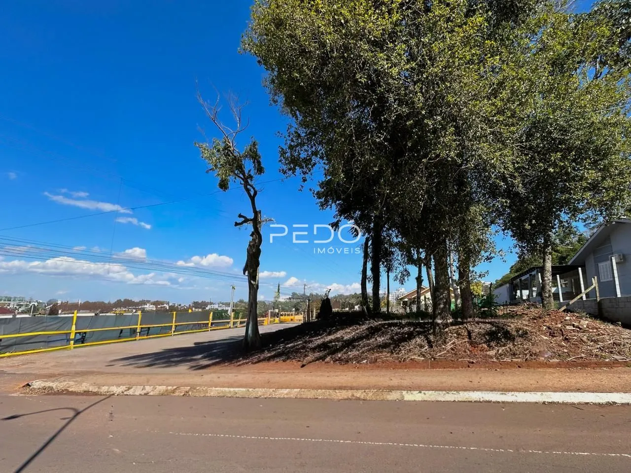 Vista da propriedade com árvores e estrada no exterior.