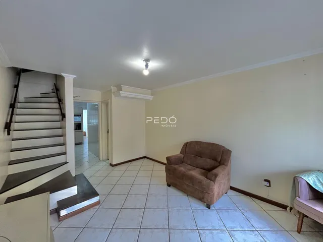 Sala de estar com piso de cerâmica e sofá no interior de uma residência.