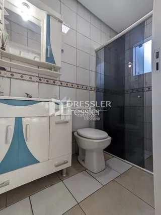 Foto de um banheiro com piso cerâmico e vaso sanitário branco.