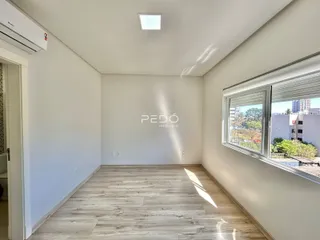Sala de estar com piso de madeira clara e janela.