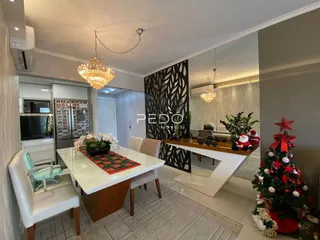 Sala de jantar iluminada com mesa branca e decoração de Natal.
