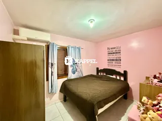 Quarto com cama e cortinas em uma sala de estar em Lajeado.