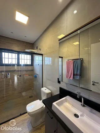 Foto de um banheiro moderno com azulejos e box de vidro.