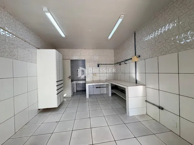 Hall de entrada com revestimento cerâmico nas paredes e piso.
