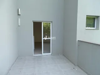 Interior de um corredor com porta branca e piso de cerâmica clara.