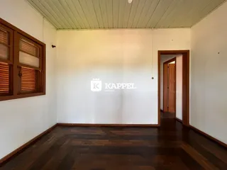 Sala de estar com piso de madeira e paredes brancas.