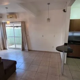 Ambiente interno com piso de cerâmica e portas de vidro que dão acesso ao exterior.