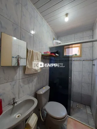 Foto de um banheiro com azulejos brancos e um lavatório.
