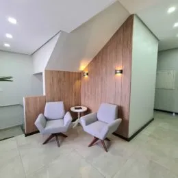 Foto de uma sala de estar com dois assentos e painéis de madeira.