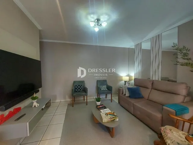 Sala de estar com sofá e televisão em um imóvel no Brasil.