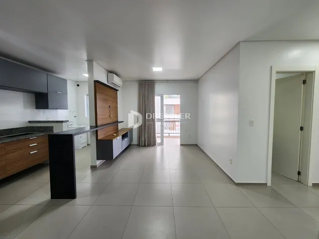 Ambiente interno de uma sala de estar com piso de cerâmica e armários modernos.