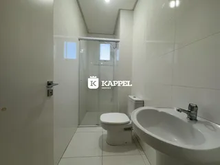 Banheiro com revestimento branco e louças sanitárias.