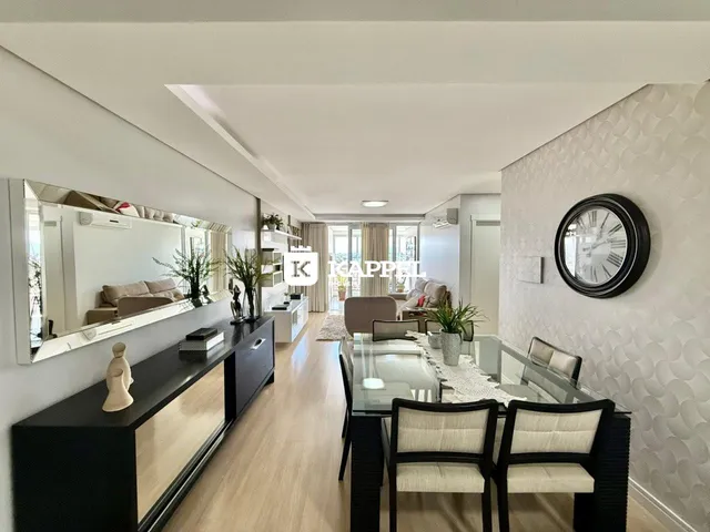 Sala de estar e jantar com piso de madeira clara e móveis modernos.