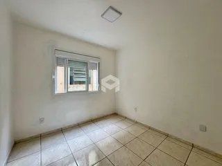Vista interna de uma sala com piso de cerâmica e janela.