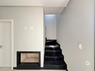 Hall de entrada com escadaria escura e nicho na parede