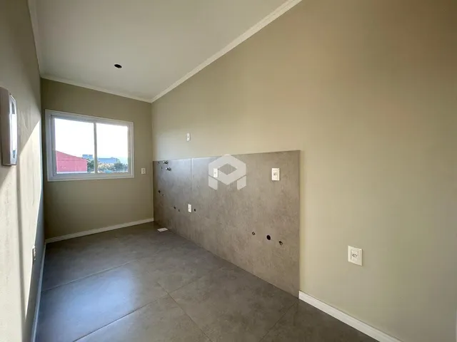 Hall da casa com paredes claras e piso cinza.