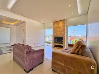 Sala de estar com dois sofás e vista para o exterior.