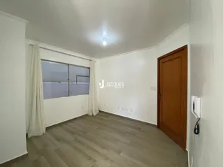 Interior de uma sala com piso de madeira clara.