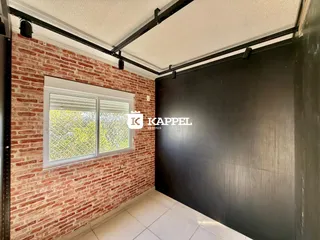 Parede de tijolos aparentes com uma janela de abertura visível em um ambiente interno.