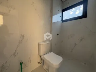 Banheiro com revestimento de mármore branco nas paredes.