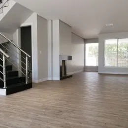 Foto de um ambiente interno com piso de madeira e escadaria.