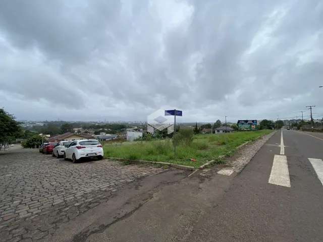 Vista externa de uma rua com vegetação e veículos em Lajeado, Brasil.