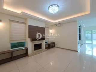 Sala de estar com lareira e piso claro em imóvel no Brasil.