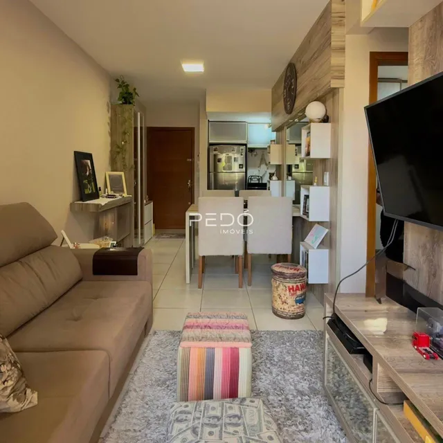 Sala de estar com sofá e área de jantar em um apartamento.