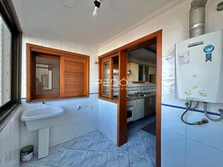 Vista de um banheiro com azulejos brancos e armários de madeira em uma residência.