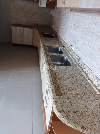 Mostra uma bancada de cozinha com pia de aço inoxidável.