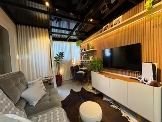 Sala de estar moderna com painel de madeira e televisão.