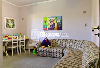 Sala de estar com sofá e mesa de centro em ambiente claro.