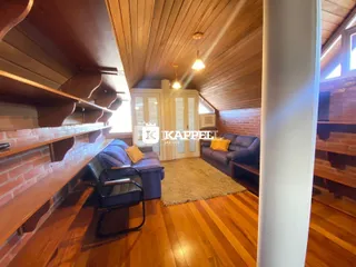 Esta é uma sala de estar com piso de madeira e sofá azul.