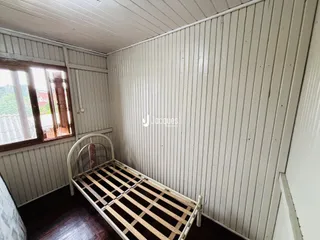 Quarto com cama de madeira e piso de madeira.