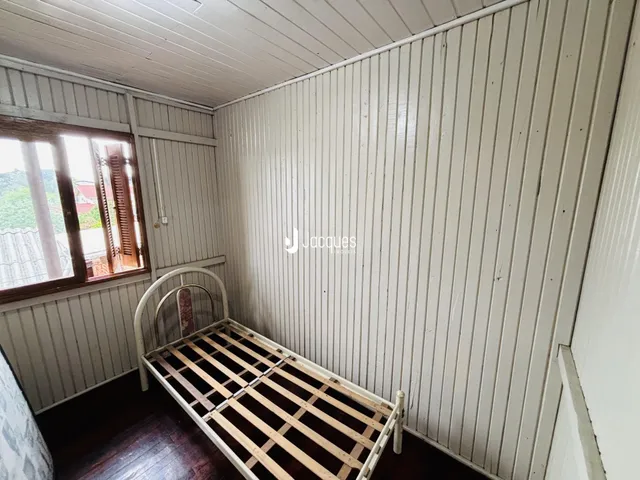 Quarto com cama de madeira e piso de madeira.