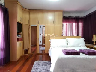 Quarto com armários de madeira e piso de madeira no imóvel em Lajeado.