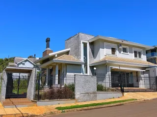 Fachada de uma residência em Lajeado, Brasil, com cerca e muro frontal.